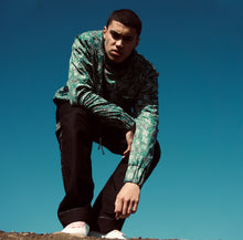 Load image into Gallery viewer, Model Editorial Image YOUNG WAR Paisley Crewneck Luxury Fashion Top Green with drawstrings Front View paired with Tux Pants